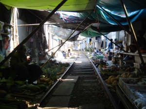 The train arrives in the middle of this market in Ratchaburri, Thailand